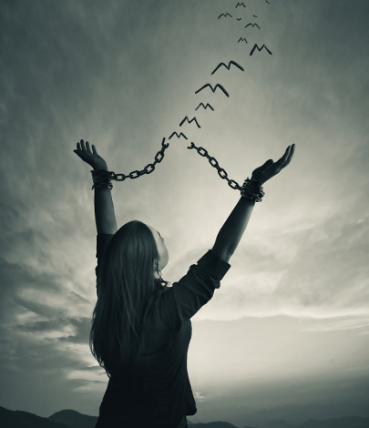 A woman breaks her chains as the links turn into freedom birds